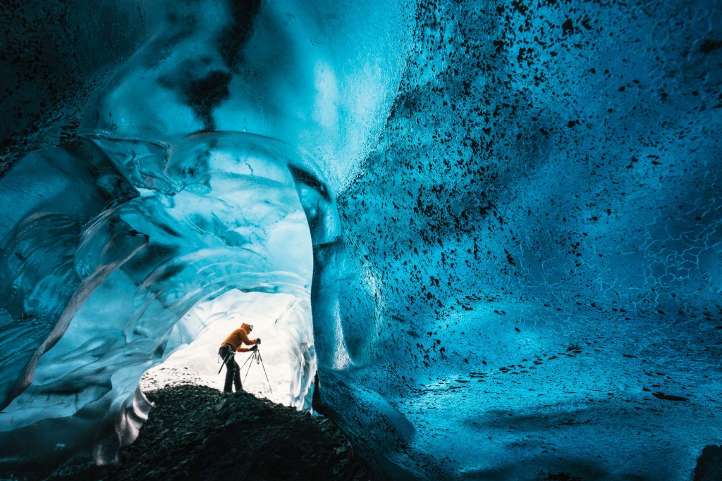 Wednesday 25th November 2015, Vatnajökull national park, Iceland: Photographer Mikael Buck with assistance from renowned local Icelandic guide Einar Runar Sigurdsson, explored the frozen world of Vatnajökull glacier in Iceland using Sonys world first back-illuminated full-frame sensor  which features in the ?7R II camera. His images were taken without use of a tripod or any image stitching techniques in photoshop. This was made possible through Sonys new sensor technology, allowing incredibly detailed low-light hand held photography. Previously images this detailed would have required carrying bulky equipment to the caves, some of which can require hiking and climbing over a glacier for up to two hours to to access. This picture: Inside the 'ABC cave' - which stands for Amazing Blue Cave. Guide Einar Runar Sigurdsson is seen taking a photo at the entrance to the cave PR Handout - editorial usage only. Photographer's details not to be removed from metadata or byline. For further information please contact Rochelle Collison at Hope & Glory PR on 020 7014 5306 or rochelle.collison@hopeandglorypr.com Copyright: © Mikael Buck / Sony 07828 201 042 / mikaelbuck@gmail.com